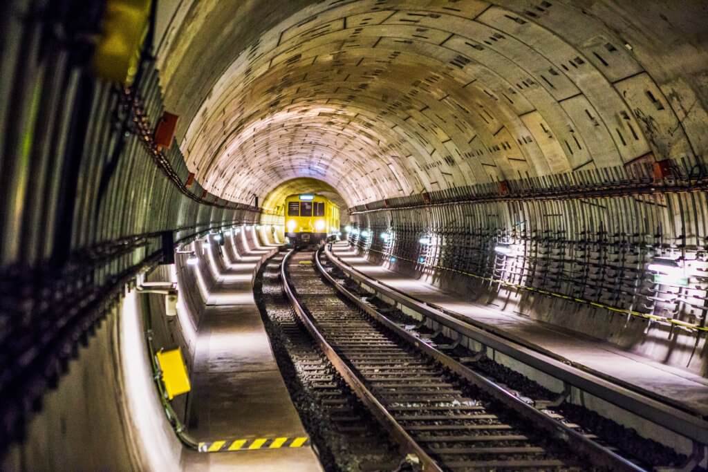 Image of a subway tunnel underground with a yellow train coming